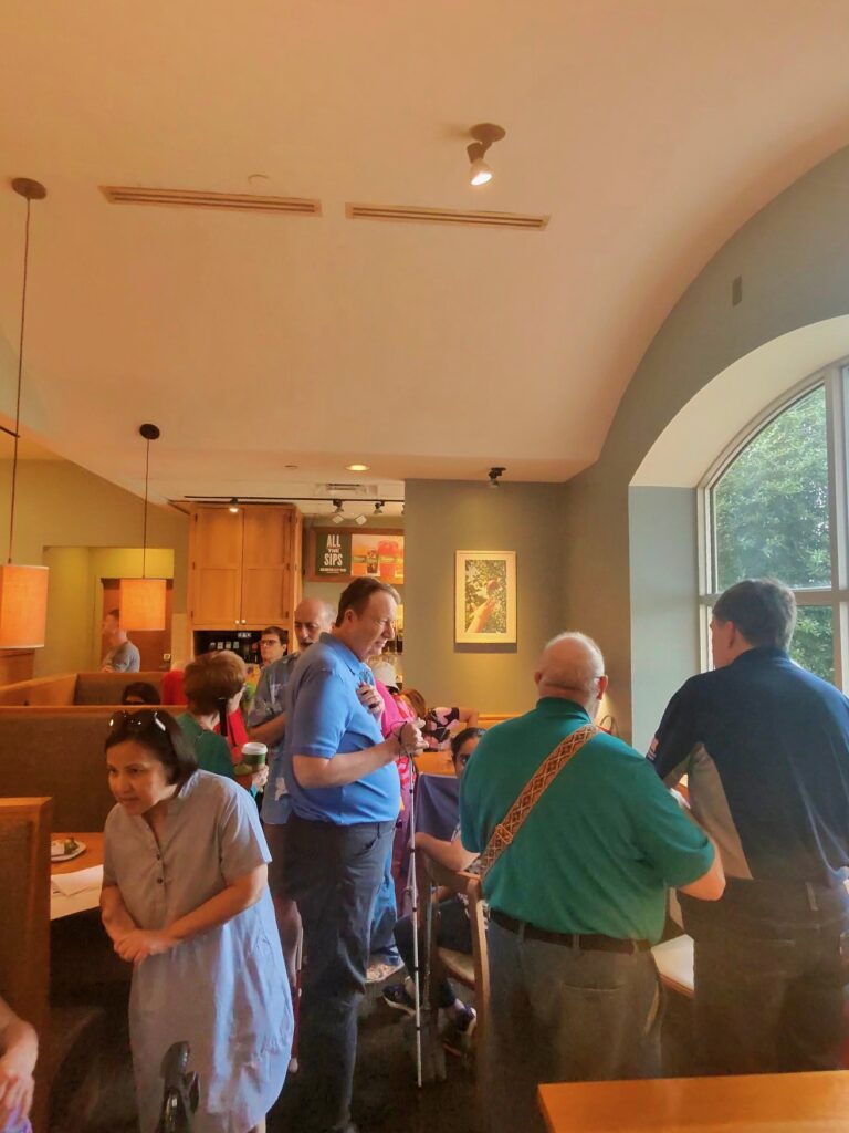 group of people standing and socializing at Panera 'Dinner with Friends'